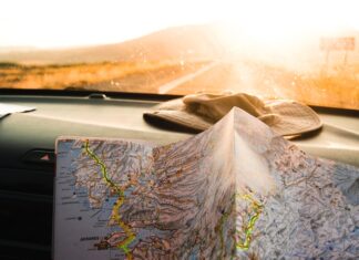 Who Will Find Us? person holding blue and brown map