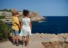 A Difficult Character two children standing near cliff watching on ocean at daytime