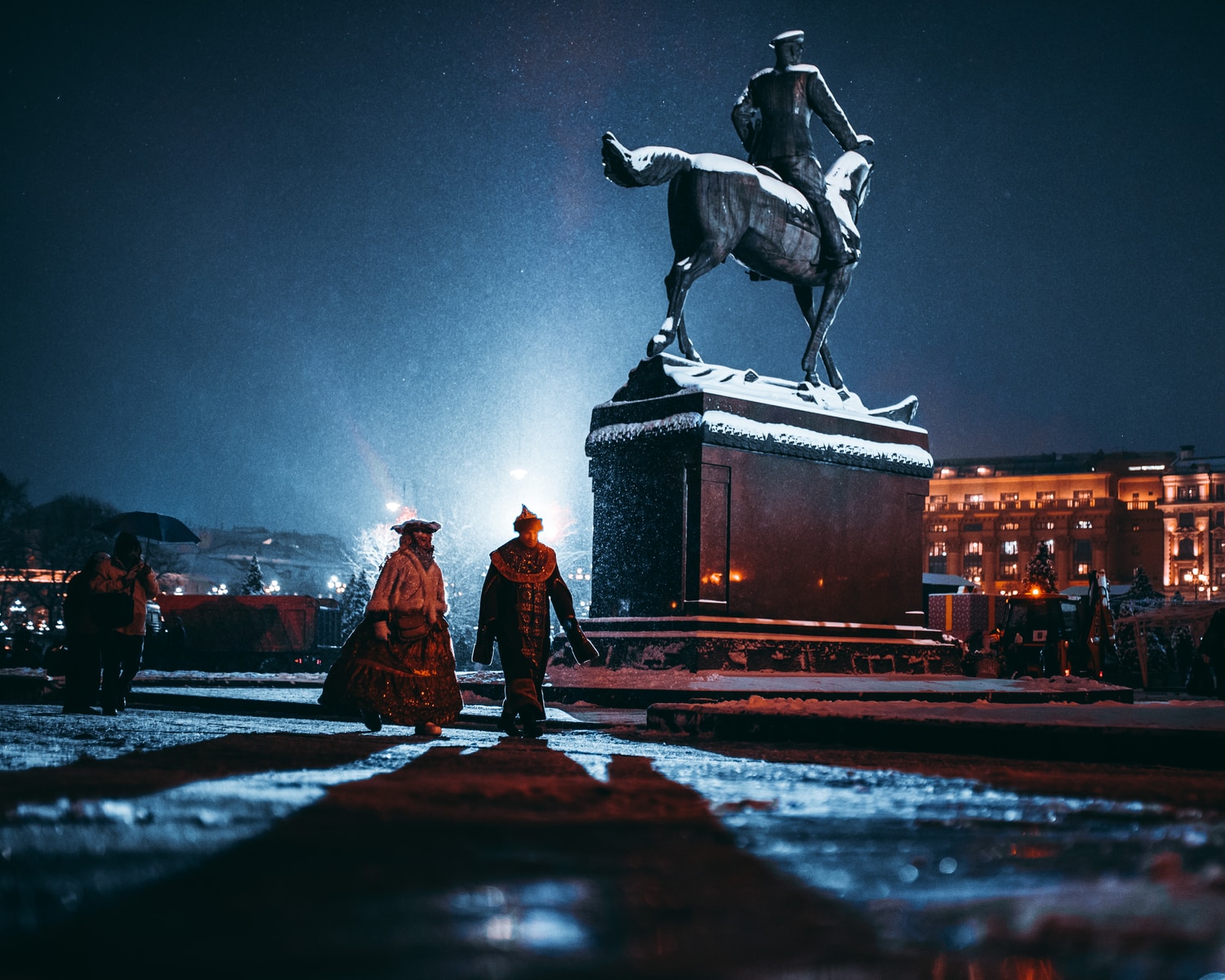 two person walking near person riding horse statue