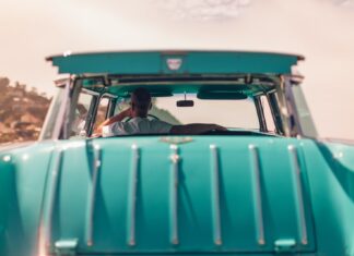 Liberated Me selective focus photography of person riding teal car