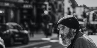 Worry man beside the road with cars