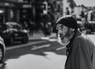 Worry man beside the road with cars