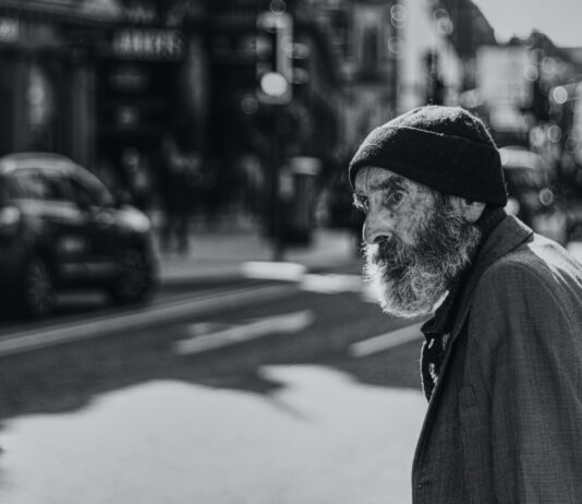 Worry man beside the road with cars