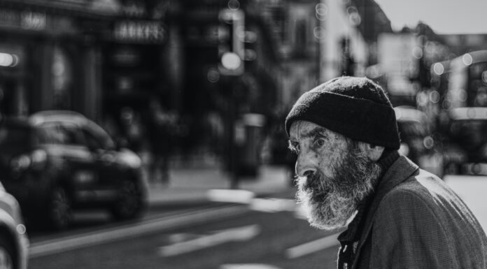 Worry man beside the road with cars