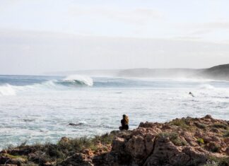 Sara woman sitting on rock near the beach