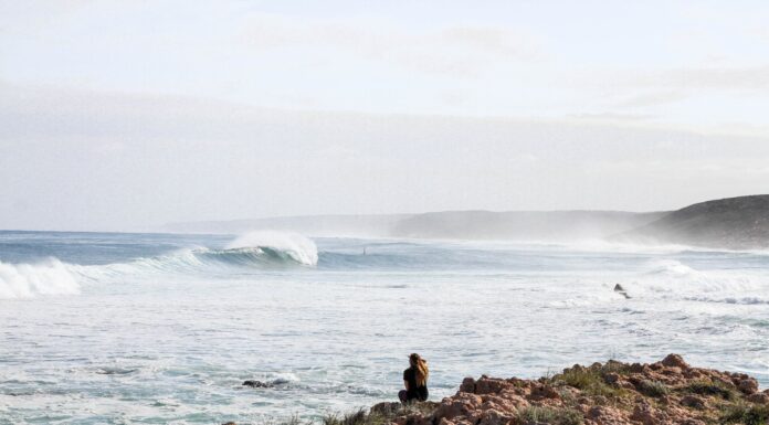 Sara woman sitting on rock near the beach