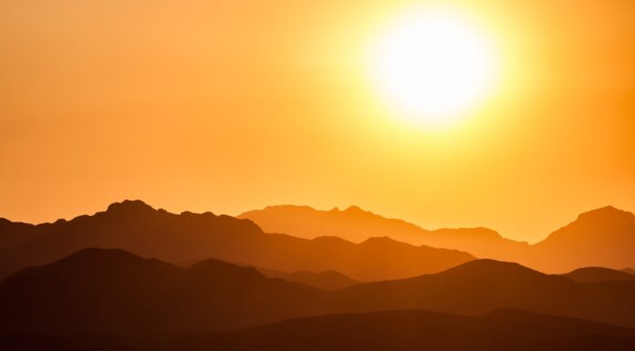 YOUR UGLY SUN silhouette of mountains under orange sky
