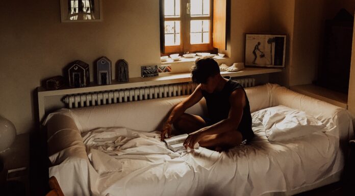 I CAN’T CALL YOU PAUL man sitting on bed beside opened window