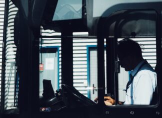 One Night silhouette photography of man driving bus