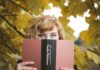 E. E. Dickinson selective focus photography of woman holding Emily Dickinson book