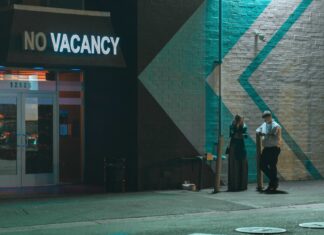 VACANCY man and woman standing beside white wall