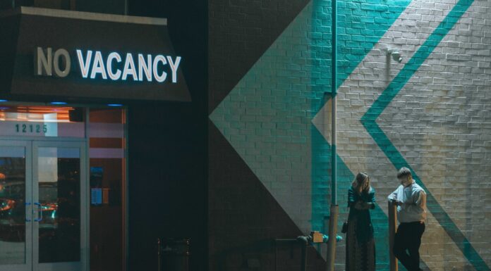 VACANCY man and woman standing beside white wall