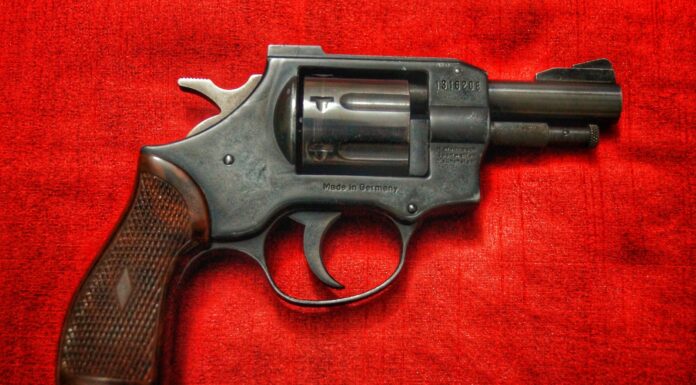 7:40 black and silver revolver on red textile