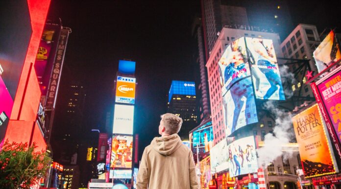 Signs man standing on road infront of high-rise buildi