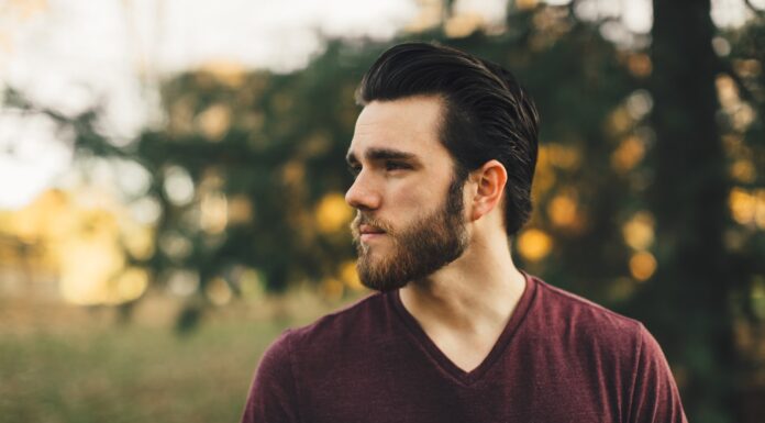 Square Jaw and GSOH man wearing maroon V-neck t-shirt in forest