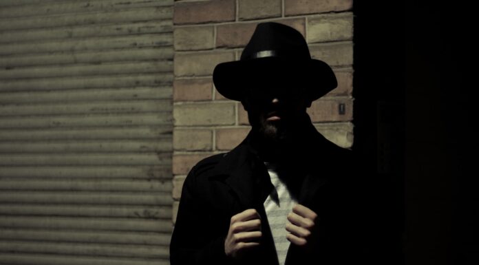 6:09 a.m. man wearing black fedora hat and black suit jacket