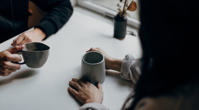 Aphasia woman in black long sleeve shirt holding black ceramic mug