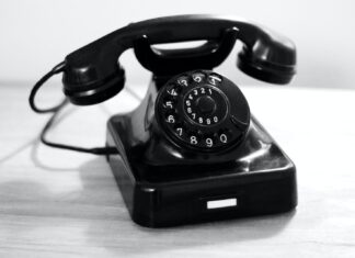 THE PLEASURES OF WORK black rotary phone on white table
