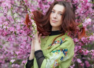 Big, Long, Red Hairs woman in green and yellow long sleeve shirt holding pink flowers