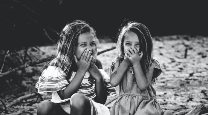 My Sister Cape grayscale photography of two girls closing their mouths
