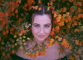 A Bit of Breast Showing woman in black shirt surrounded by brown leaves