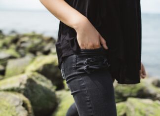 Valid Title person wearing black denim bottoms near on body of water during daytime