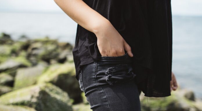 Valid Title person wearing black denim bottoms near on body of water during daytime