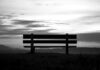 nobody a black and white photo of a bench on a hill