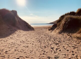 The inland behind the mountain a sandy beach with footprints in the sand