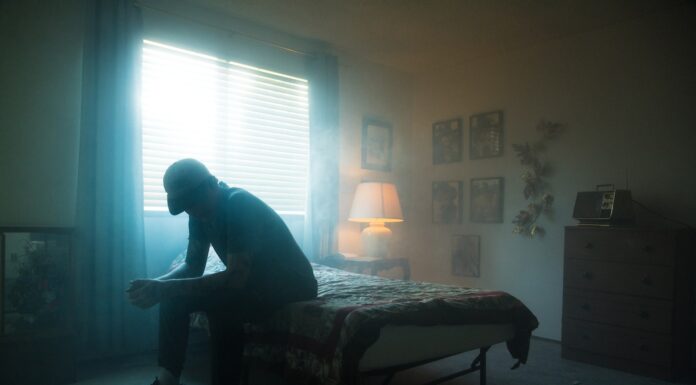 I might not be here long man in black jacket sitting on bed