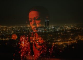 EVERYWHERE woman reflection on glass overlooking city at night