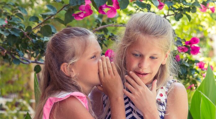 Epiphany girl in pink tank top beside girl in blue and white striped tank top