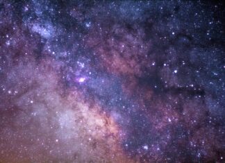 A Yellow Bus Passes The stars and galaxy as seen from Rocky Mountain National Park.
