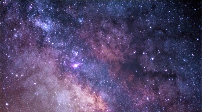 A Yellow Bus Passes The stars and galaxy as seen from Rocky Mountain National Park.