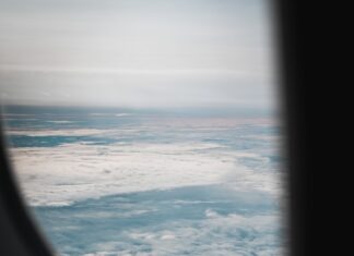 Mediums an airplane window with a view of the sky and clouds