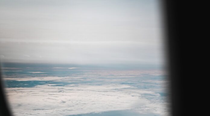 Mediums an airplane window with a view of the sky and clouds