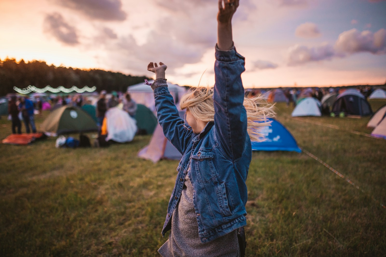 Writing Group a woman raising her arms in the air in front of tents
