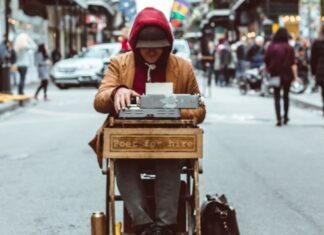 WHY YOU SHOULDN’T BE A POET man sitting on table typing on typewriter