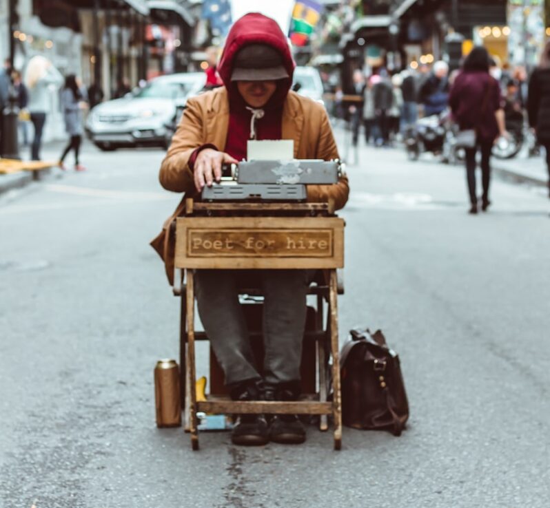 man sitting on table typing on typewriter