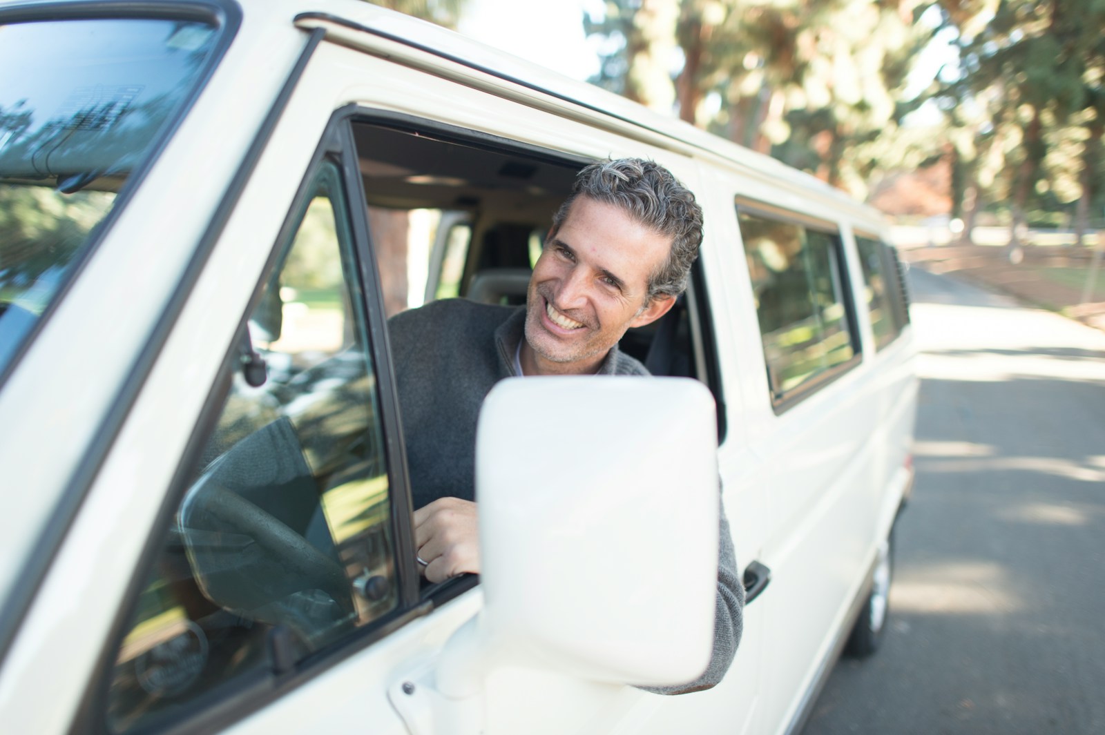 BULLSHIT INSURANCE man in gray sweater leaning on van window