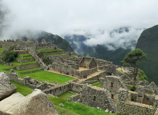 Prendere Lucciole Per Lanterne (To Take Fireflies For Lanterns) brown and gray concrete houses on green grass field under white cloudy sky during daytime