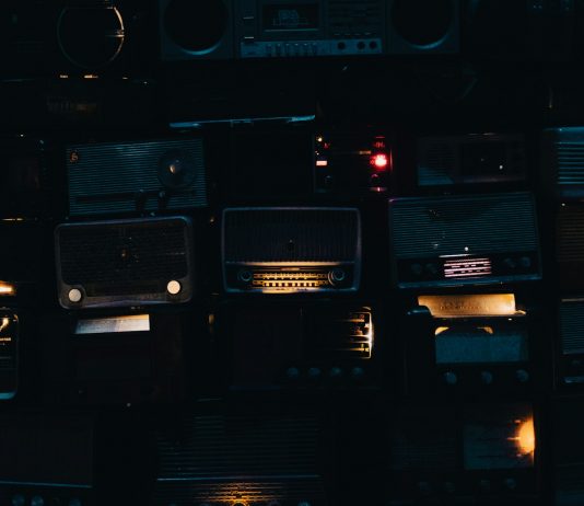 Gospel Radio Blues a wall of old radio's in a dark room