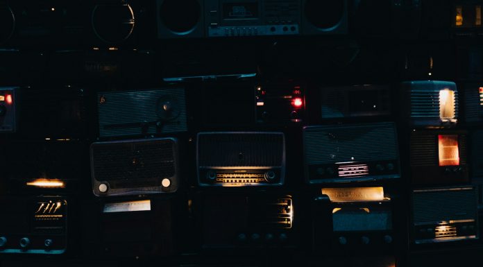 Gospel Radio Blues a wall of old radio's in a dark room