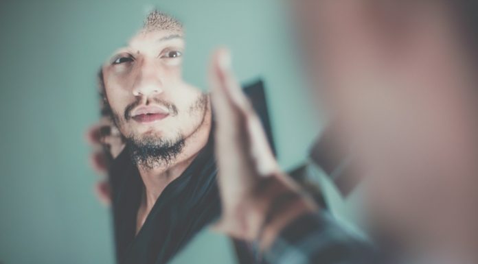 Visions selective focus photography of man's reflection on a broken mirror