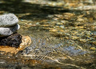Unmoored gray stones on body of water
