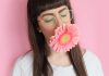 Bangs woman wearing eyeglasses with flower in mouth