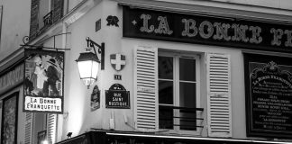 One Hundred & 15 Words An old parisian cafe sign and building.