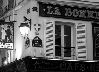 One Hundred & 15 Words An old parisian cafe sign and building.