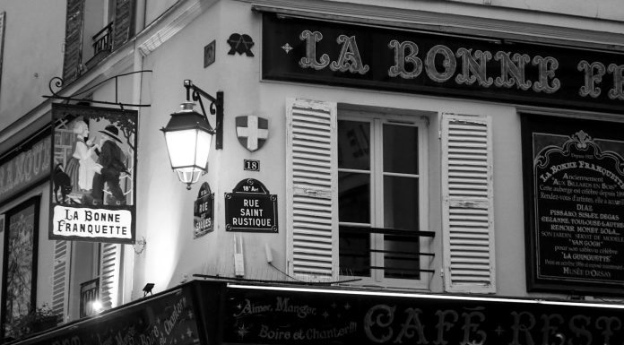 One Hundred & 15 Words An old parisian cafe sign and building.