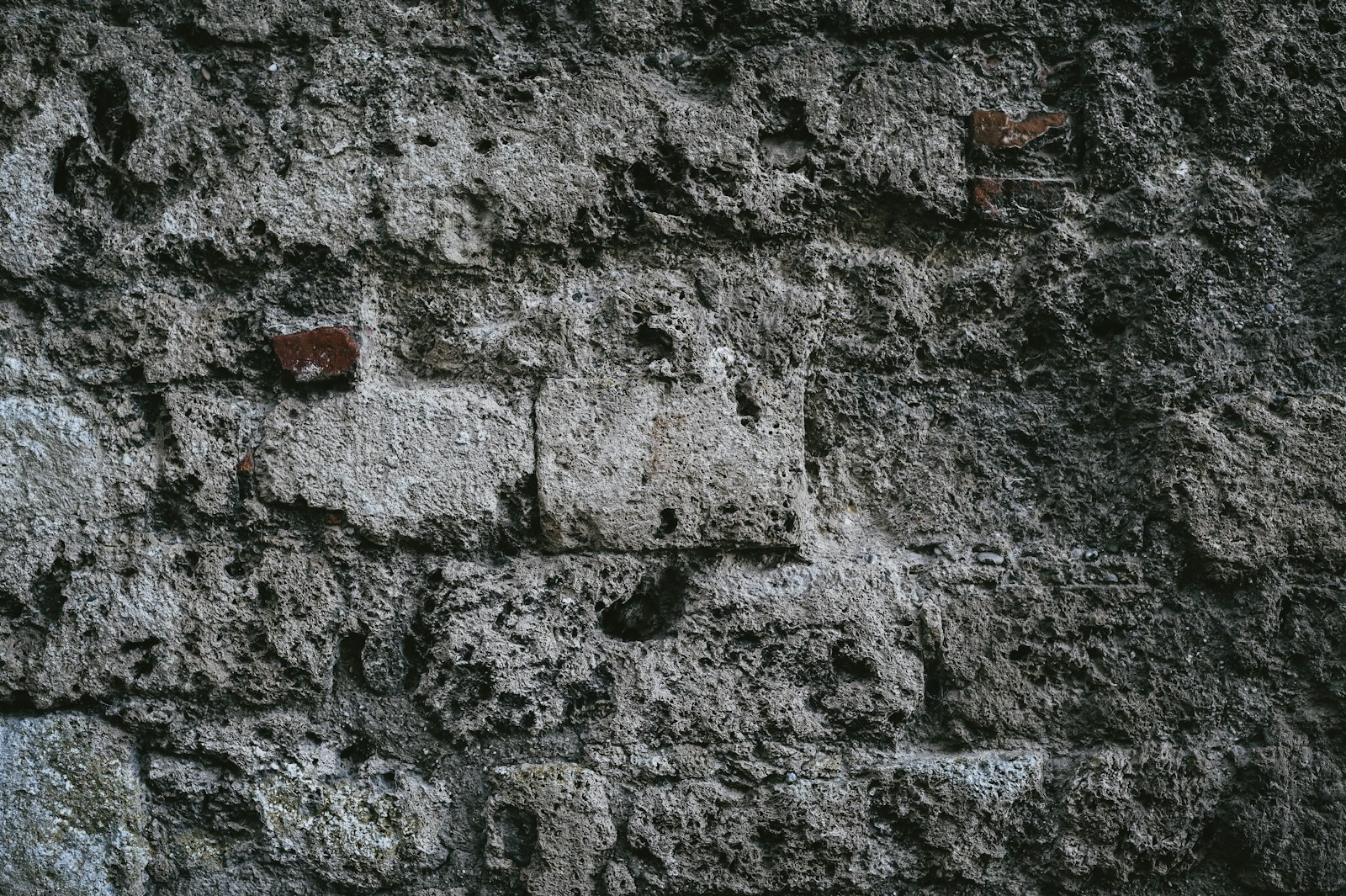 a close up of a stone wall with small holes in it
